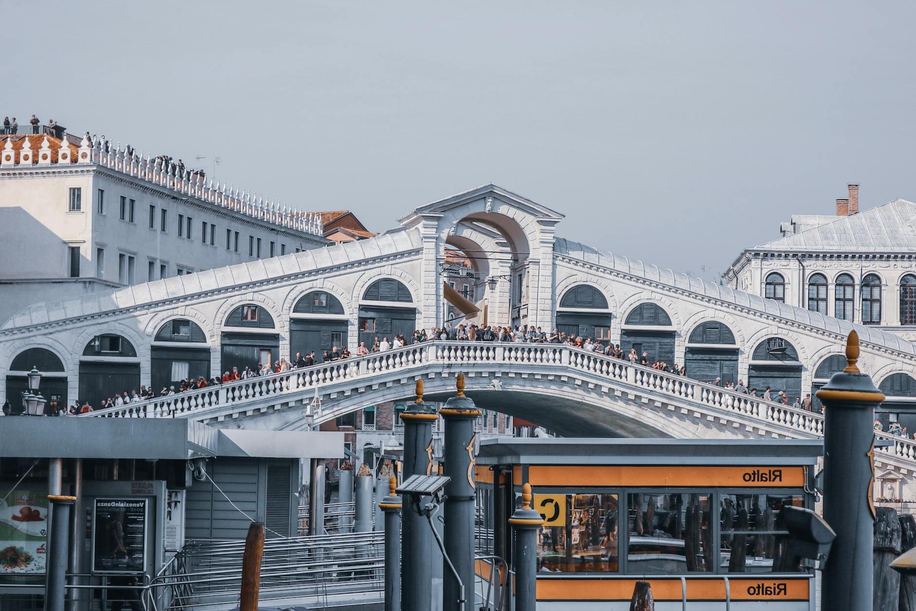 Unrecognizable people on Rialto Bridge against buildings in city