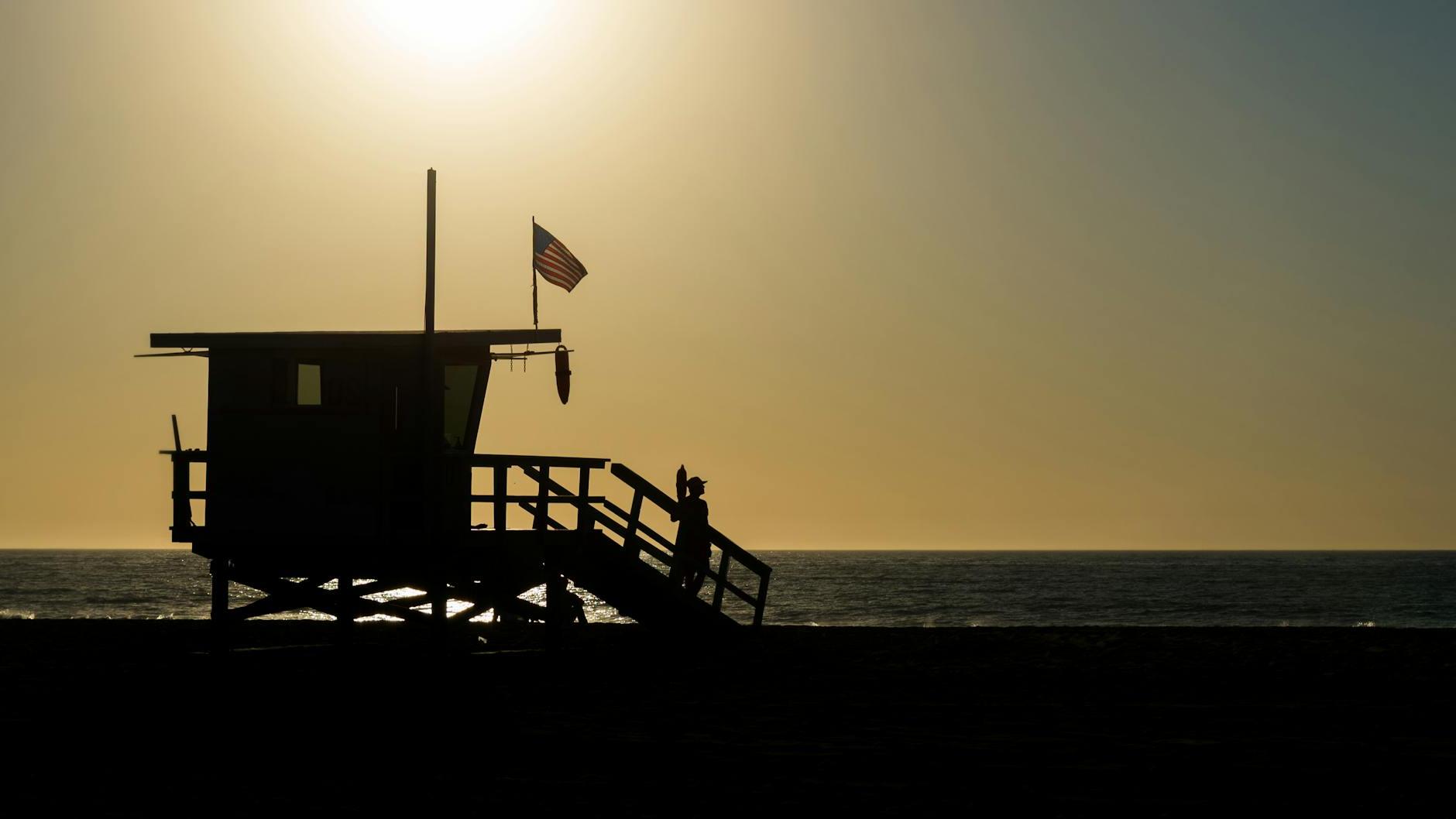 Silhouette of Life Guard House Near Ocean during Sunset