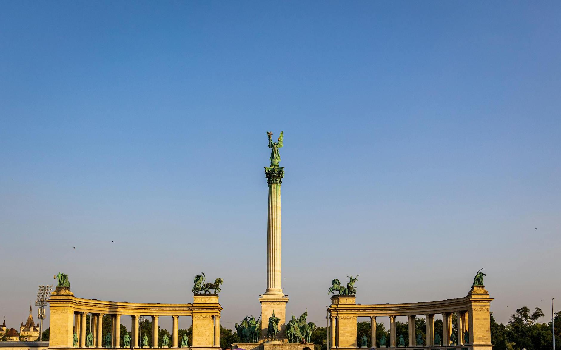 Low angle of Heroes Square and column with Archangel Gabriel on top against colonnades in Budapest