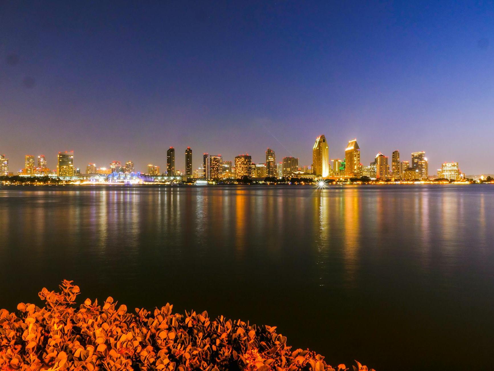 City Skyline Across Body of Water During Night Time