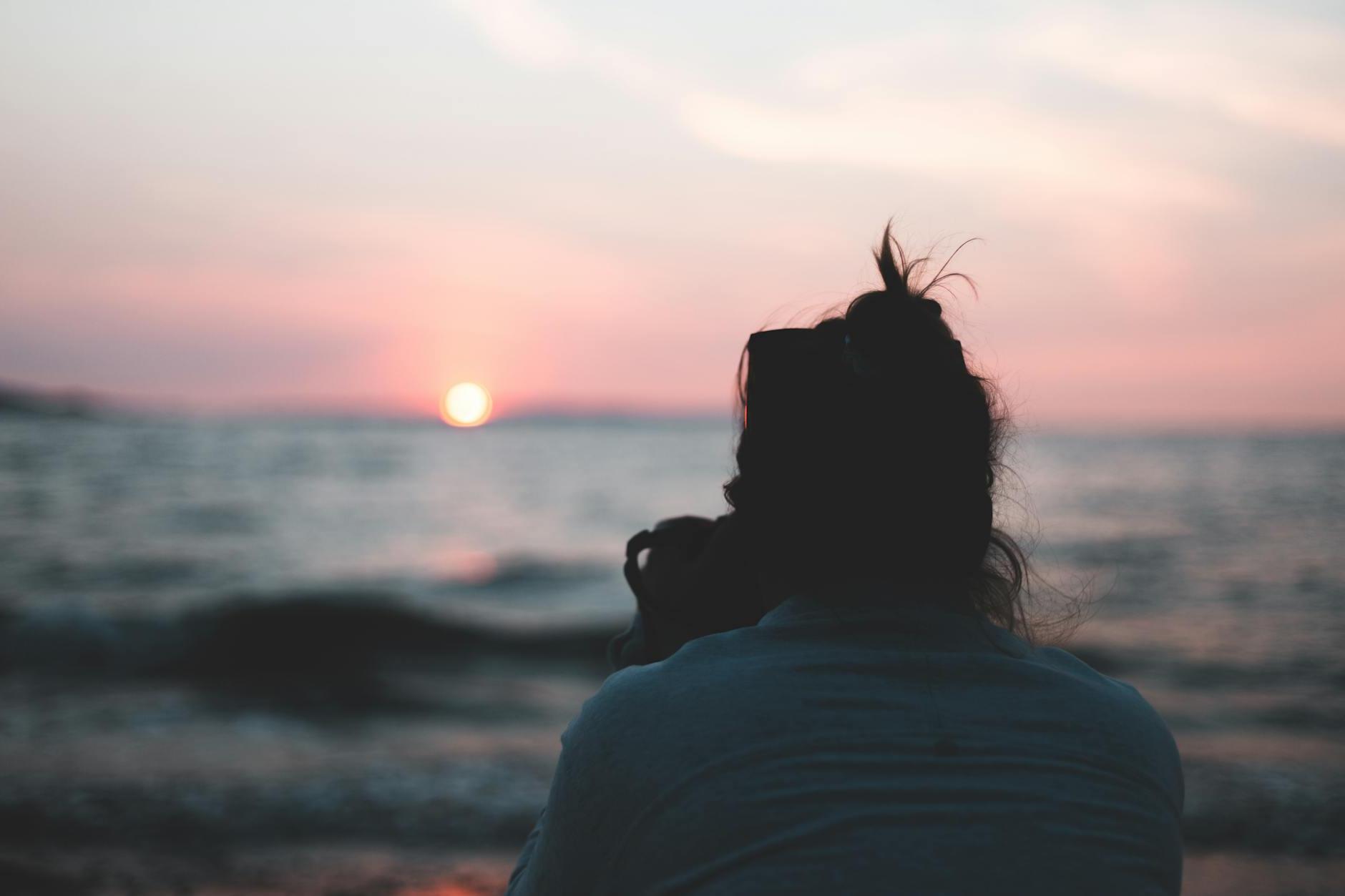 Woman in White Shirt Standing Near Sea during Sunset